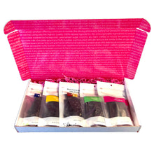 Load image into Gallery viewer, Open rectangle gift box lid up with view of  5 - 3oz bags of brittle fanned out to fill the box. Pink crinkle paper cushions the bags inside the box.