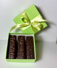 Load image into Gallery viewer, 3 chocolate caramel bars laying in light green, square, paper box with a satin light green ribbon and bow wrapping the box.