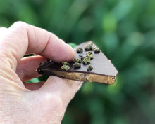 Load image into Gallery viewer, Close up of a hand holding a piece of the toffee brittle.