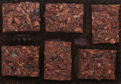 View from above of the opened “Crushed Cacao Nib” with six rectangle-shaped chocolate truffles arranged in two rows, 3 truffles per row, each in paper candy cup. 