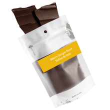 Load image into Gallery viewer, Warm ginger root brittle pouring out of 3oz sized bag with label stating “Warm Ginger Root Toffee Brittle” and NeoCocoa logo.