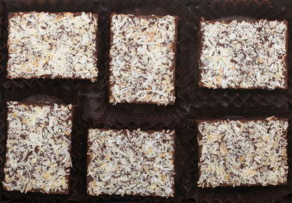 View from above of the opened “Toasted Coconut” with six rectangle-shaped chocolate truffles arranged in two rows, 3 truffles per row, each in paper candy cup. 