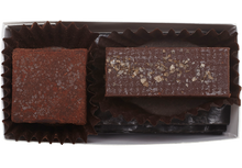 Load image into Gallery viewer, Inside the rectangle box, 1 cube shaped lime truffle (coated in cocoa powder) and 1 rectangle shaped almond butter truffle with a few flakes of salt. 