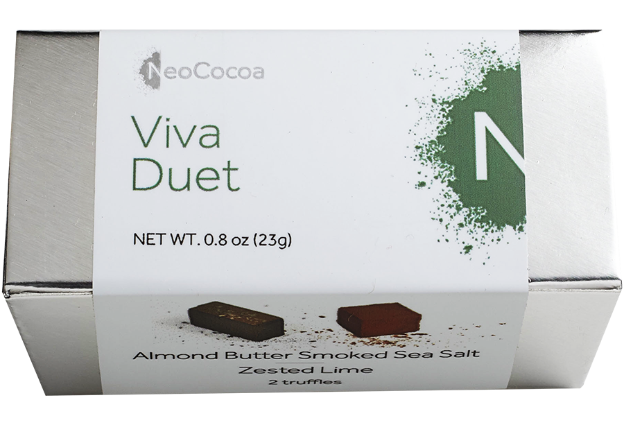 2 dimensional rectangle silver box with a label wrapped around the box stating, “Viva Duet” with NeoCocoa logo and net weight  0.8 oz (23g). Can see a little of the side of the label with image of one almond butter smoked sea salt truffle and one zester lime truffle.  