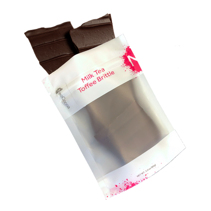 Milk Tea brittle pouring out of 3oz sized bag with label stating “Milk Tea Toffee Brittle” and a pink NeoCocoa logo.
